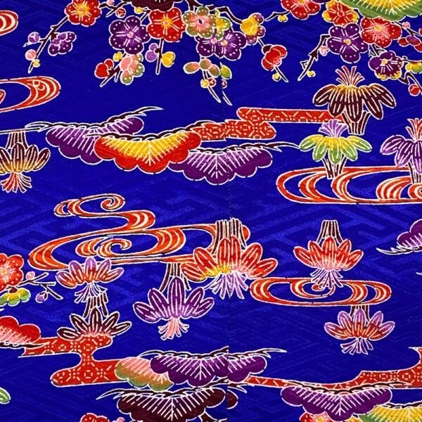 Detail Stoff: Sofakissen aus blauem kimono- Stoff mit floralem Muster in rot, lila, gelb, grün, stilisierte japanisches Mandelblüten Lotusblüten, Blätter und organische Formen.